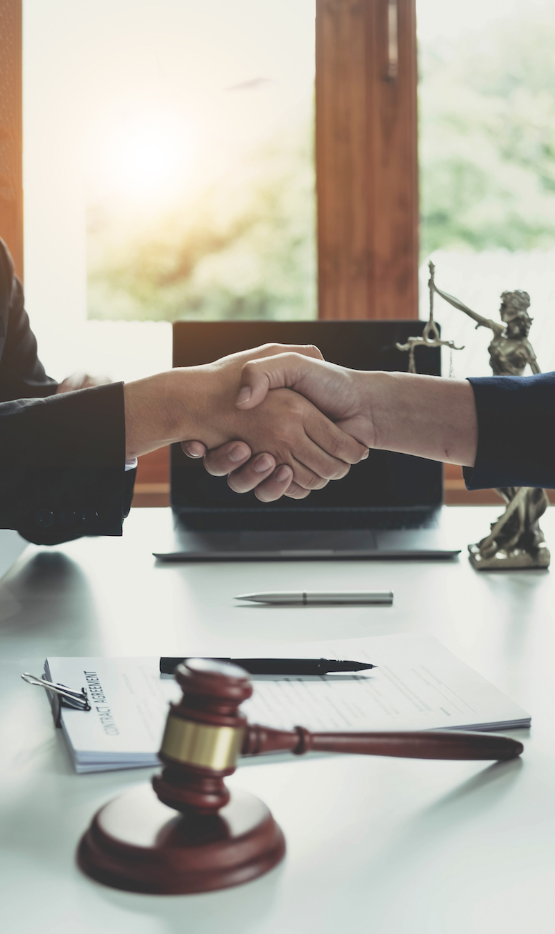 Businessman shaking hands to seal a deal with his partner lawyers or attorneys discussing a contract agreement..